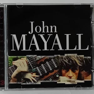 Pode incluir: Uma caixa de CD com fundo preto e texto branco que diz "John Mayall" em negrito. A imagem mostra um close-up de uma mão de homem tocando uma guitarra com corpo de madeira e cordas de metal. A caixa de CD faz parte de uma série chamada "Master Series".
