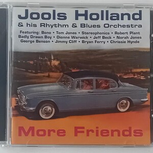 May include: A CD case with a blue car on the front. The title of the album is "More Friends" and the artist is "Jools Holland & his Rhythm & Blues Orchestra". The album features artists such as Bono, Tom Jones, Stereophonics, Robert Plant, Badly Drawn Boy, Dionne Warwick, Jeff Beck, Norah Jones, George Benson, Jimmy Cliff, Bryan Ferry, and Chrissie Hynde.