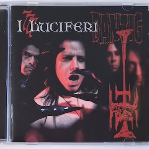 May include: A CD case featuring the album cover for "I Luciferi" by Danzig. The artwork has a dark, gothic theme with a central figure with open mouth, surrounded by other figures. The band name is in red, stylized lettering.