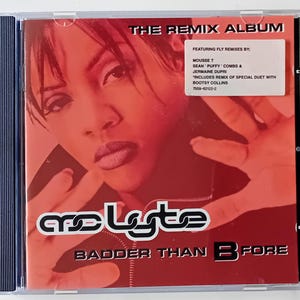 Op de afbeelding: Een rode CD-hoes met een vrouwengezicht op de voorkant. De titel van het album is "The Remix Album" en de artiest is "MC Lyte". De albumtitel is "Badder Than Before".