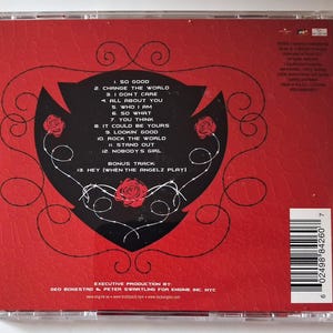 Puede incluir: Una caja de CD roja con un gr&aacute;fico negro en forma de coraz&oacute;n que contiene una lista blanca de doce canciones y una pista adicional. El dise&ntilde;o incluye ilustraciones de rosas rojas, l&iacute;neas negras en espiral y un c&oacute;digo de barras.