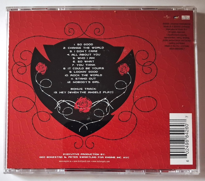 Puede incluir: Una caja de CD roja con un gr&aacute;fico negro en forma de coraz&oacute;n que contiene una lista blanca de doce canciones y una pista adicional. El dise&ntilde;o incluye ilustraciones de rosas rojas, l&iacute;neas negras en espiral y un c&oacute;digo de barras.