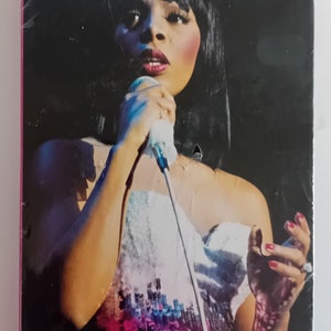 May include: A black and white photograph of Donna Summer singing into a microphone. The album cover features the text "Donna Summer Chronicles 3 Classic Albums".