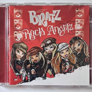 Puede incluir: Un CD de m&uacute;sica Bratz Rock Angelz en una caja de pl&aacute;stico transparente. La portada muestra cinco personajes ilustrados con atuendos de rock sobre un fondo rojo con gr&aacute;ficos de altavoces. El texto dice Bratz Rock Angelz en letras blancas.
