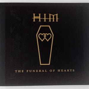 May include: Black album cover with gold lettering for the band HIM. The album title is "The Funeral of Hearts" and features a gold outline of a coffin with two intertwined hearts.
