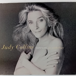 Può includere: Una custodia per CD con un ritratto in bianco e nero di Judy Collins. La copertina dell'album mostra il testo "Judy Collins" in oro, con "forever an anthology" sotto. L'immagine è un primo piano di Collins.
