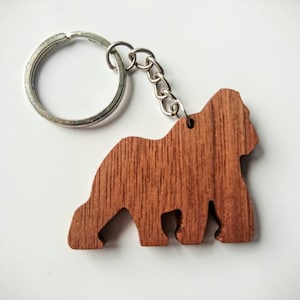May include: A wooden keychain shaped like a gorilla, with a silver key ring attached.