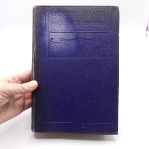 May include: A dark blue hardcover book with the title "Episcopal Palaces Province of York" embossed on the front cover.