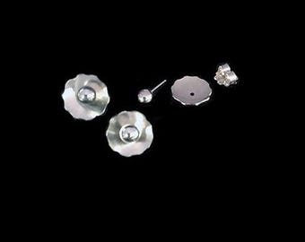 May include: A pair of silver earrings with a flower-shaped design and a small pearl in the center. The earrings are shown with the backs and posts.