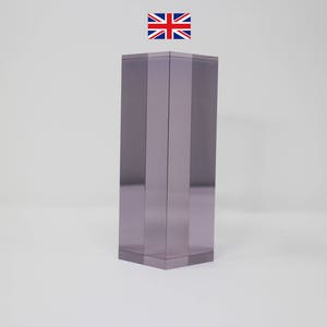 Könnte beinhalten: Ein klares Glasprisma mit einem violetten Farbton. Das Prisma ist rechteckig und hat eine glatte, polierte Oberfläche.