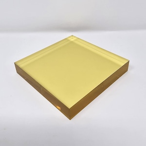 Könnte beinhalten: Ein quadratischer, transparenter Acryl-Präsentationsständer mit einem leichten Gelbstich. Der Ständer ist aus dickem, strapazierfähigem Acryl gefertigt und hat eine glatte, polierte Oberfläche.