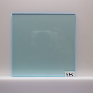 Peut inclure: Une pièce carrée d'acrylique bleu clair avec un léger effet givré. L'acrylique a une surface lisse et polie. La pièce est étiquetée "W505".