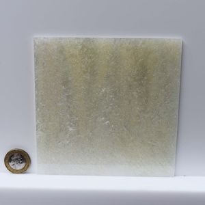 May include: A close-up of a sheet of clear, translucent, sparkly, light green glitter paper.