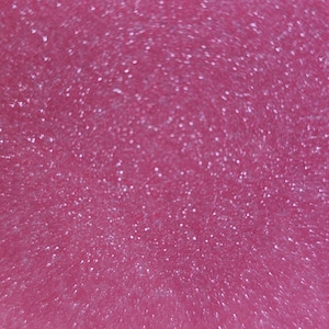 May include: A close-up of a pink surface with a sparkly, glittery texture.