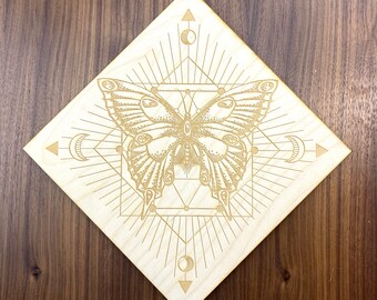 May include: A wooden plaque with a laser-etched design of a butterfly inside a geometric pattern. The butterfly is detailed with intricate markings and is surrounded by a radiating sunburst pattern.