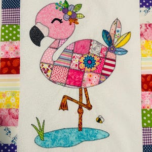 May include: A colorful flamingo quilt with a patchwork design. The flamingo is pink with a black beak and is adorned with a floral crown. The body features a patchwork of various fabrics. The quilt has a white background and a patterned border.