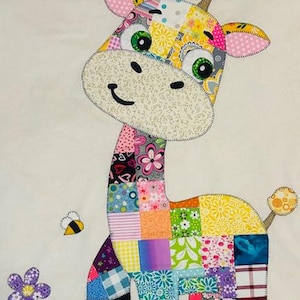 May include: A colorful patchwork giraffe applique with a smiling face, green eyes, and patterned ears. The giraffe's body is made of various fabric squares in floral and geometric designs. A bee and a flower are also included.