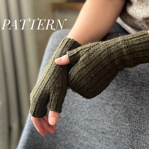Könnte beinhalten: Ein Paar olivgrüne Fingerlose Handschuhe mit einem gerippten Strickmuster. Die Handschuhe sind aus einem weichen, warmen Material gefertigt und perfekt, um Ihre Hände im Winter warm zu halten.