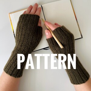 May include: A pair of olive green fingerless knitted gloves with the word "PATTERN" in white text.