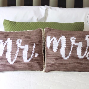 Op de afbeelding: Twee bruine gehaakte kussens met witte letters. De kussens spellen "Mr." en "Mrs."