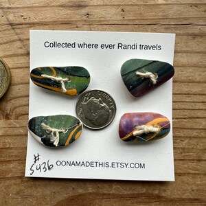 May include: Four colorful, abstract, ceramic buttons with a white string threaded through each. The buttons are on a white card with the text "Collected where ever Randi travels # 5436 OONAMADETHIS.ETSY.COM"