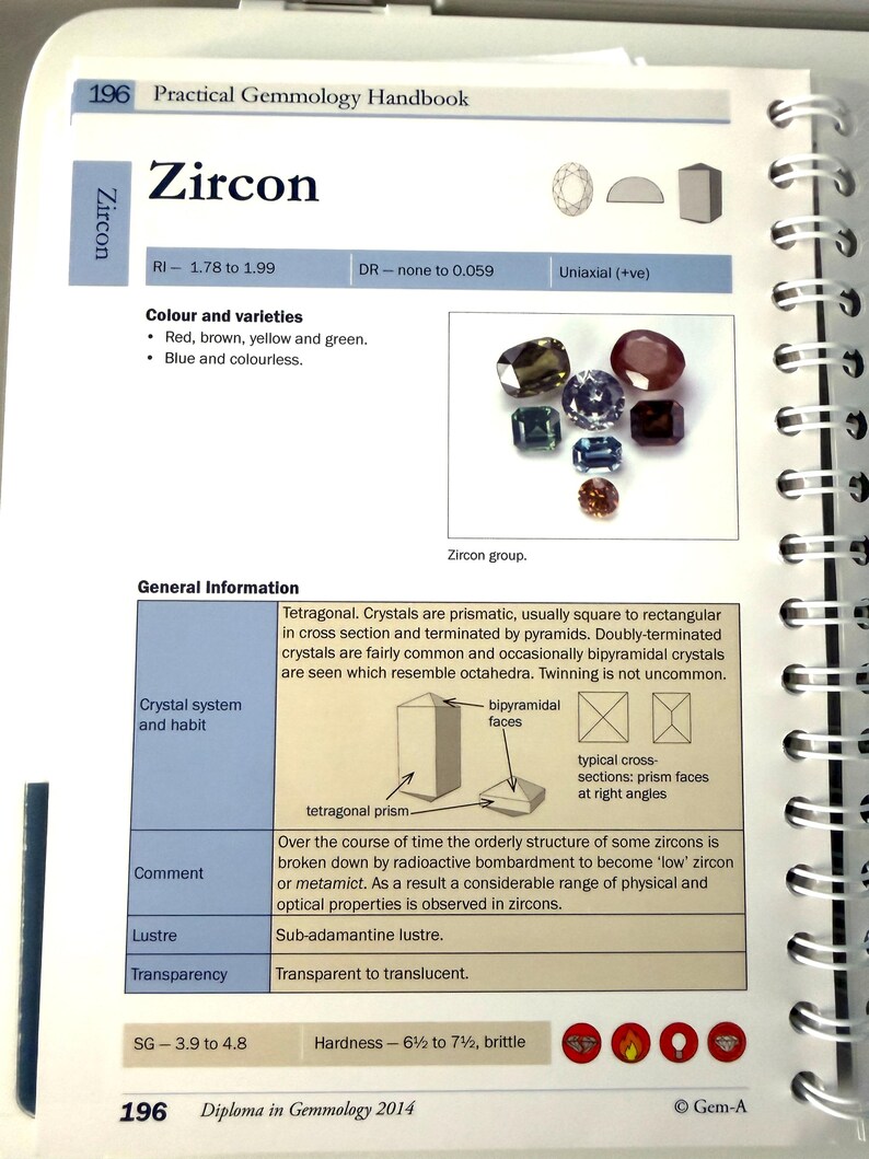 May include: Open page from a gemology handbook, featuring the title "Zircon" and a variety of zircon gemstones in different colors. The page includes technical details, diagrams, and the text "Practical Gemmology Handbook".