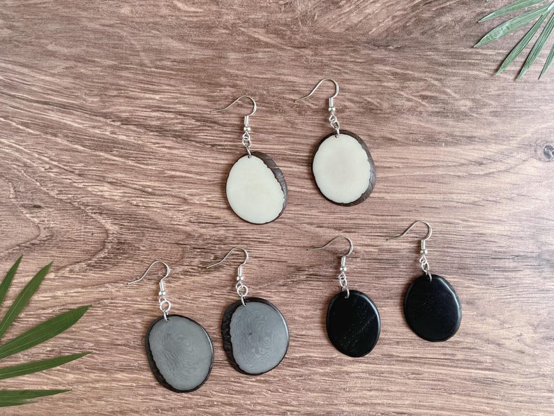May include: Four pairs of earrings with silver hooks and oval-shaped pendants. Two pairs have black and white oval pendants, and two pairs have black and gray oval pendants.