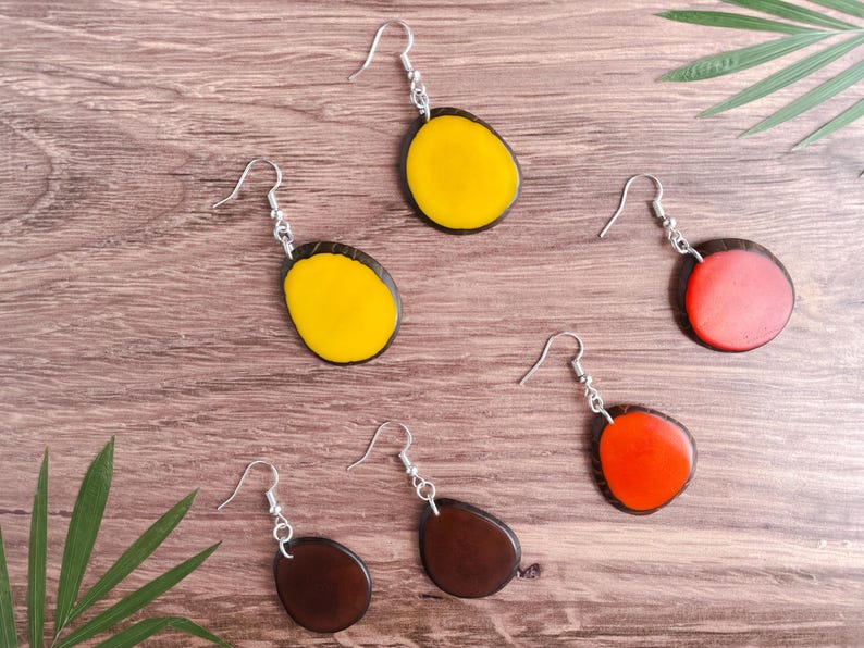 May include: A set of six earrings with wooden bases and colorful resin inlays. The earrings are in three different colors: yellow, red, and brown.
