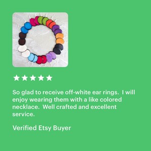 May include: A variety of colorful leather earrings in a circle. The earrings are all different colors, including red, orange, yellow, green, blue, purple, and brown. The earrings are all made of leather and have a simple, elegant design.