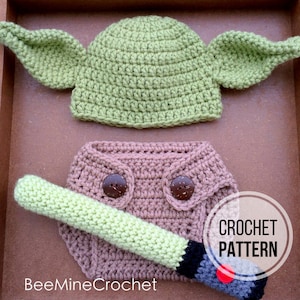 May include: Crochet pattern for a baby Yoda costume, including a green hat with ears, a brown nappy, and a green lightsaber. The pattern is available for purchase.