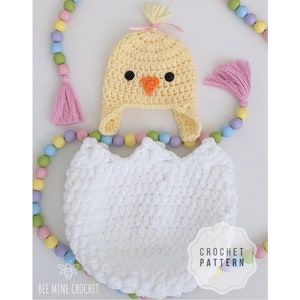 Puede incluir: Un gorro de pollito y un disfraz de huevo de crochet para un bebé recién nacido. El gorro es amarillo con un lazo rosa y ojos negros. El huevo es blanco y tiene una textura de crochet.