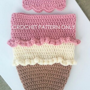 Puede incluir: Patr&oacute;n de crochet para un atuendo de beb&eacute; en forma de cono de helado. El atuendo est&aacute; hecho de hilo rosa, blanco y marr&oacute;n y tiene una cereza en la parte superior. El patr&oacute;n est&aacute; disponible para su compra.