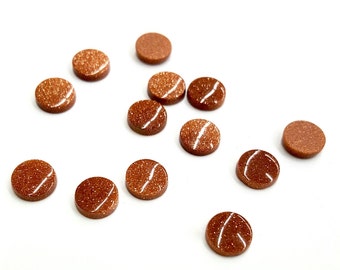 May include: A collection of twelve small, circular, flat-backed cabochons made of brown goldstone. Each piece features a smooth, polished surface with embedded metallic copper-colored flecks that create a shimmering, glittery appearance.