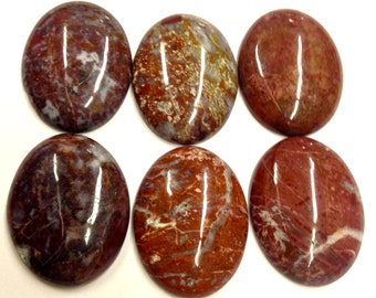 May include: Six polished oval gemstones arranged in two rows of three. Each stone features a unique pattern of deep red, brown, and white mineral veins with a smooth, glossy finish that reflects light across their rounded, symmetrical surfaces.
