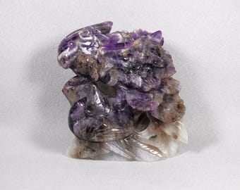 Statuetta in ametista viola raffigurante due uccelli tra i fiori, intagliata e traforata a mano.