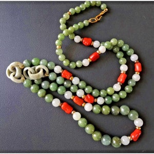 Könnte beinhalten: Eine mehrreihige Halskette mit grünen, weißen und roten Perlen. Die Halskette hat einen Jade-Anhänger mit einem goldenen Verschluss.
