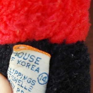 May include: A white tag with blue text that reads "House Korea" and "Shippings Shell Prods" with a circle containing the number "14".