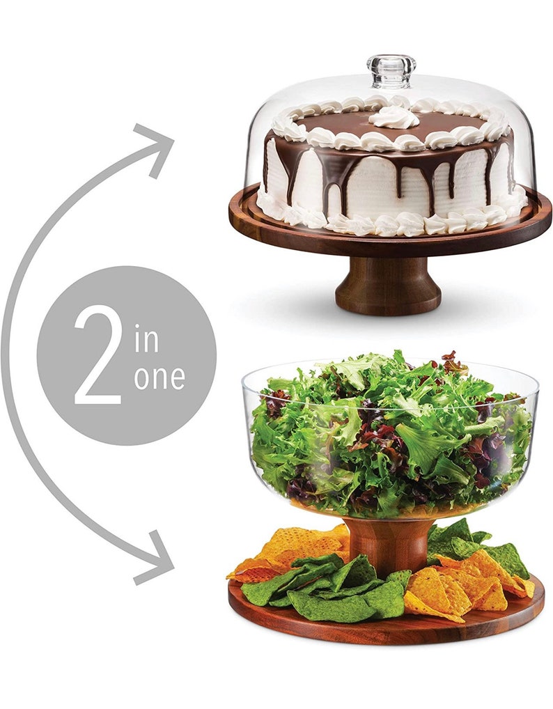 May include: A two-in-one wooden serving stand with a glass dome for cakes and a glass bowl for salads. The stand has a brown wooden base and a round wooden top. The glass dome is clear and has a knob on top. The glass bowl is clear and has a wide rim. The stand is shown with a chocolate cake under the dome and a salad in the bowl.