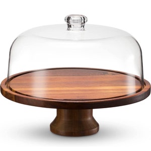May include: A wooden cake stand with a clear glass dome. The stand has a round base and a pedestal.