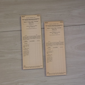 Può includere: Due vecchi buoni di deposito di razionamento dell'Ufficio americano di amministrazione dei prezzi. I buoni sono stampati su carta color crema e riportano il testo "Meat, Fats, Fish, Cheese Credits" e "State Bank of Bay, Bay, Missouri".