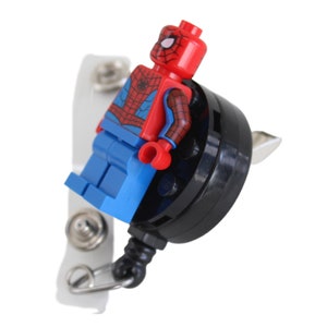 May include: A red and blue Spider-Man Lego minifigure attached to a black retractable badge reel with a silver clip.
