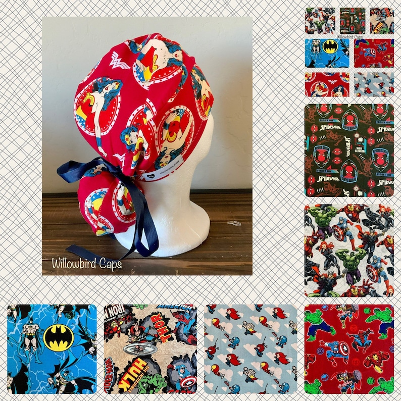 May include: A red scrub cap with a Wonder Woman print. The cap has a blue tie and is tied in a knot at the back. The cap is on a white mannequin head. The image also shows a variety of other scrub caps with different superhero prints.