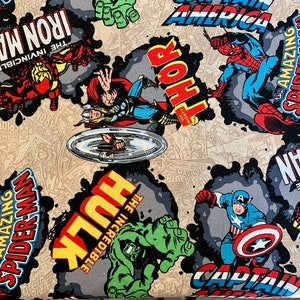 May include: A colourful fabric with a repeating pattern of comic book characters, including Spider-Man, Captain America, Thor, Hulk, and Iron Man. The fabric features the text "The Incredible Hulk", "The Amazing Spider-Man", "Captain America", "Thor", and "Iron Man".