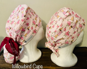 May include: Two pink surgical caps featuring a dachshund and floral design. The caps have burgundy ties and the text "Willowbird Caps" is visible at the bottom of the image.