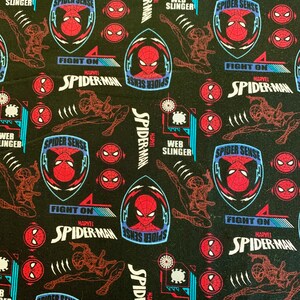 May include: Black fabric with a repeating pattern of red and blue Spider-Man characters. The pattern includes the words "Spider Sense", "Fight On", "Marvel", and "Spider-Man".