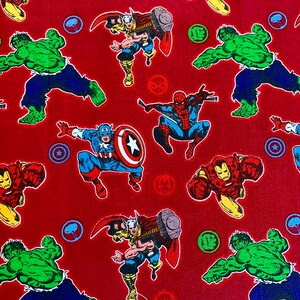 May include: Red fabric with a repeating pattern of various Marvel superheroes, including Iron Man, Captain America, Thor, Hulk, and Spider-Man. The superheroes are depicted in their classic comic book style.