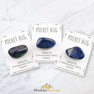 May include: Three small cards with the text "Pocket Hug" printed on them. Each card features a blue sodalite crystal and the text "Sodalite Communication, Clarity, Intuition RhodopeMinerals.Etsy.com".