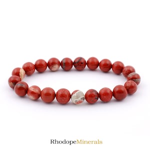 Può includere: Braccialetto di perline di diaspro rosso con una perla di diaspro bianco e grigio. Il braccialetto è realizzato con pietre naturali e misura circa 18 cm di lunghezza.