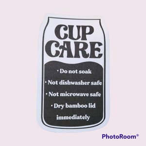 Puede incluir: Pegatina en blanco y negro con el texto "CUP CARE" e instrucciones para el cuidado de la taza: "No remojar", "No apto para lavavajillas", "No apto para microondas", "Secar la tapa de bamb&uacute; inmediatamente".