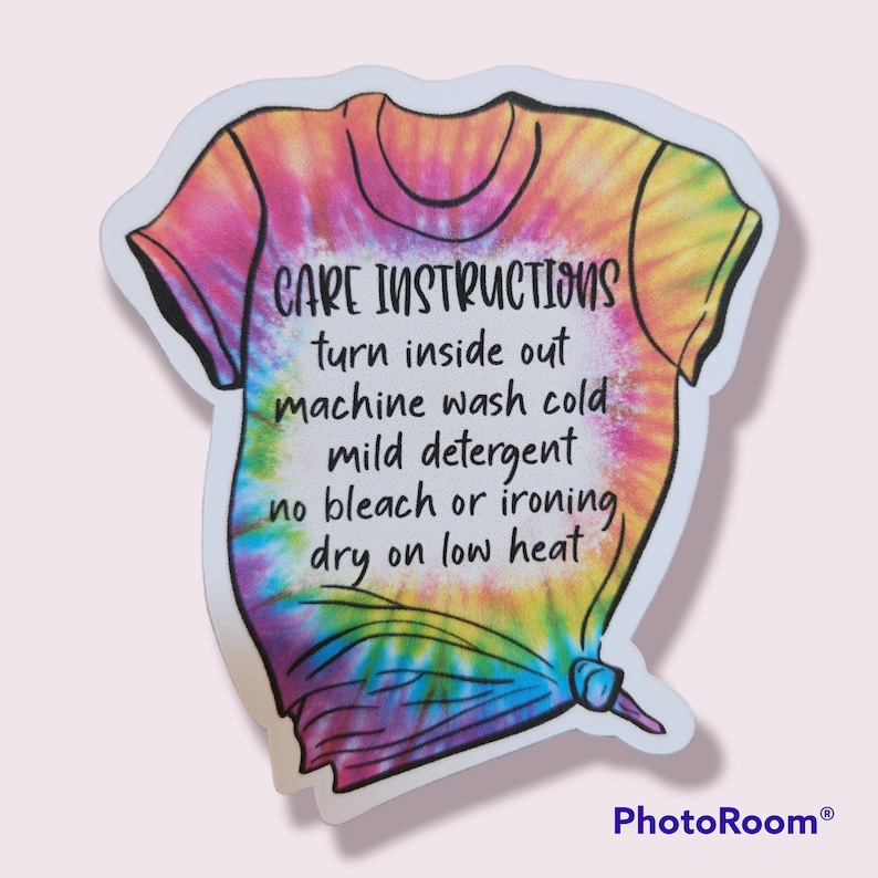 Peut inclure: Un autocollant tie-dye avec un t-shirt dessin&eacute; et des instructions d'entretien qui disent : "CARE INSTRUCTIONS turn inside out machine wash cold mild detergent no bleach or ironing dry on low heat"